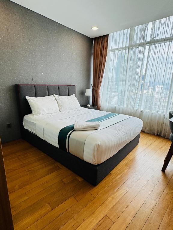 a bedroom with a bed and a large window at Vortex Suites Klcc 2bedroom & 3bedroom apartment in Kuala Lumpur
