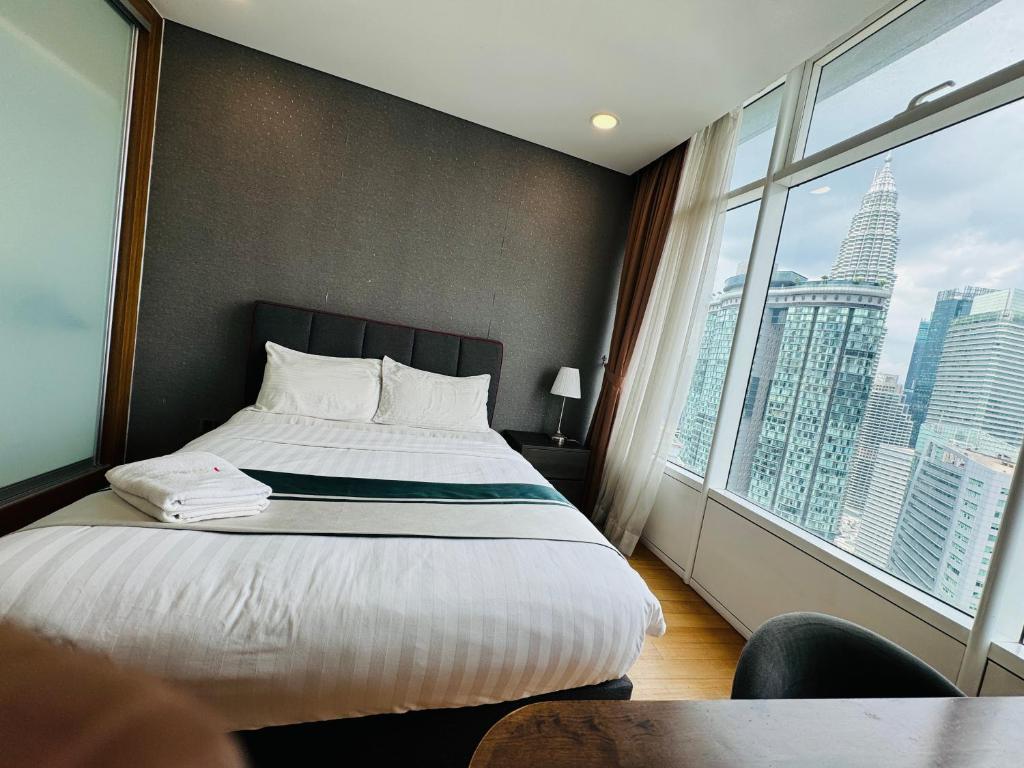 a hotel room with a bed and a large window at Vortex Suites Klcc 2bedroom & 3bedroom apartment in Kuala Lumpur