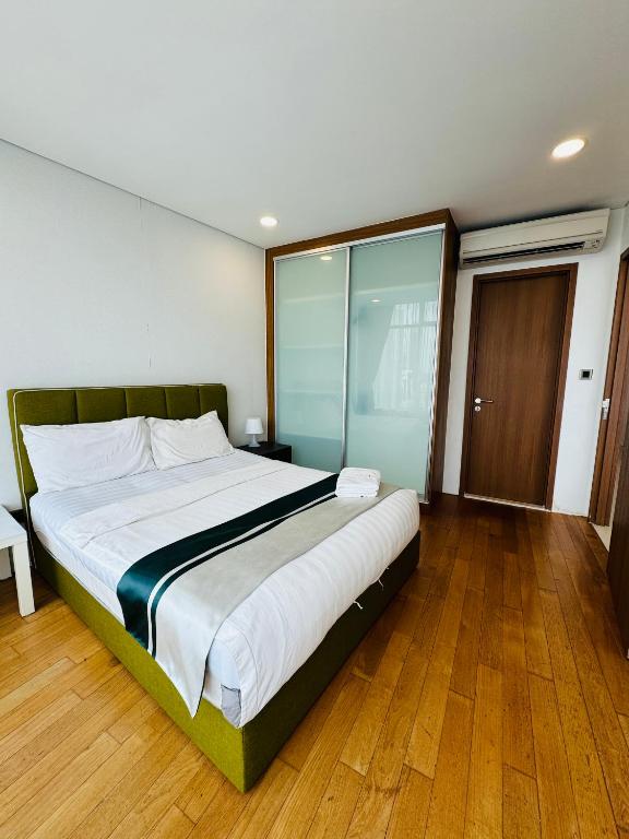 a bedroom with a large bed with a glass wall at Vortex Suites Klcc 2bedroom & 3bedroom apartment in Kuala Lumpur