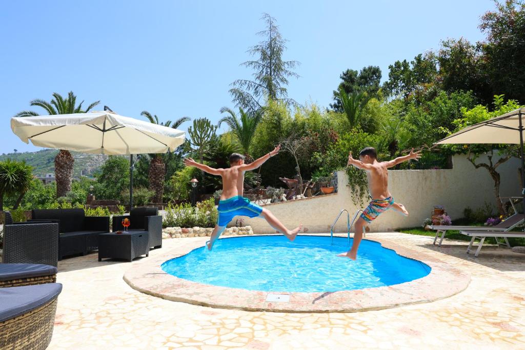 Zwei junge Männer springen in ein Schwimmbad in der Unterkunft Casita GioJa in Gasponi