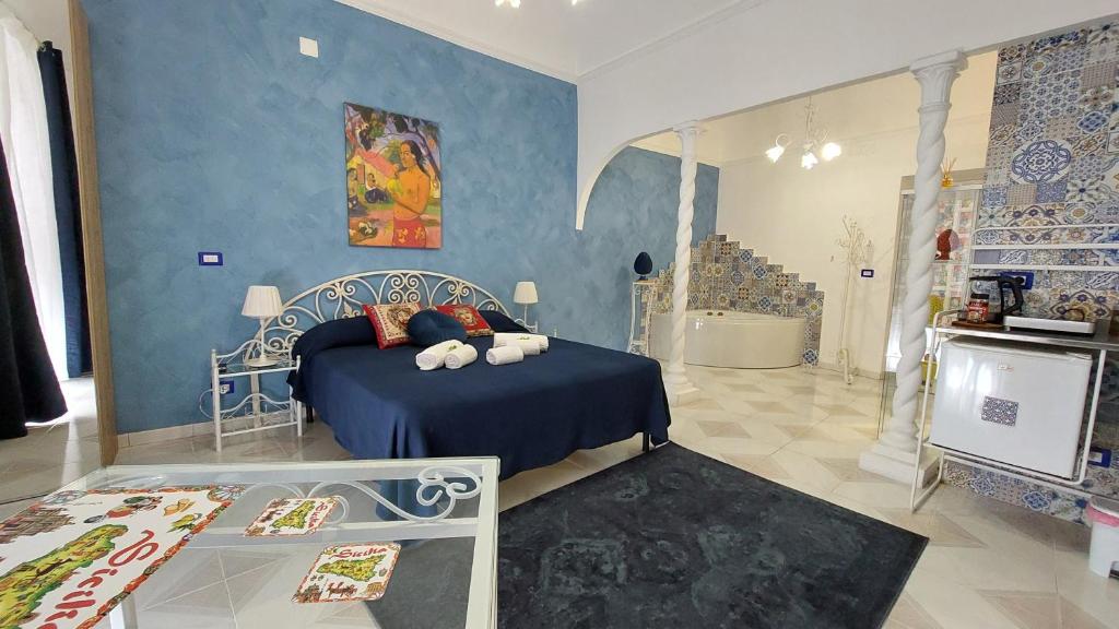 um quarto com uma cama e uma parede azul em GL Golden City Apartments em Catânia