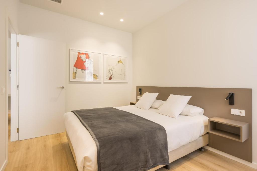 ein weißes Schlafzimmer mit einem großen Bett mit weißen Kissen in der Unterkunft Mon Suites Jardín de Ayora in Valencia