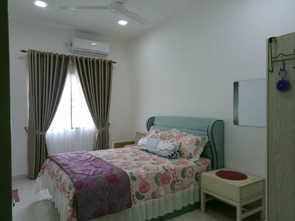 a bedroom with a bed and a window at MR OT HOMESTAY ( BAITUL RAUDHAH ) in Kepala Batas