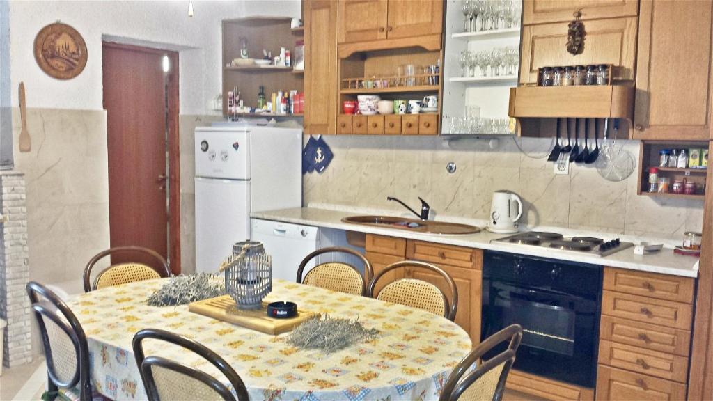 a kitchen with a table and some chairs and a kitchen with at 2 bedrooms apartement at Zlarin 200 m away from the beach with enclosed garden and wifi in Zlarin