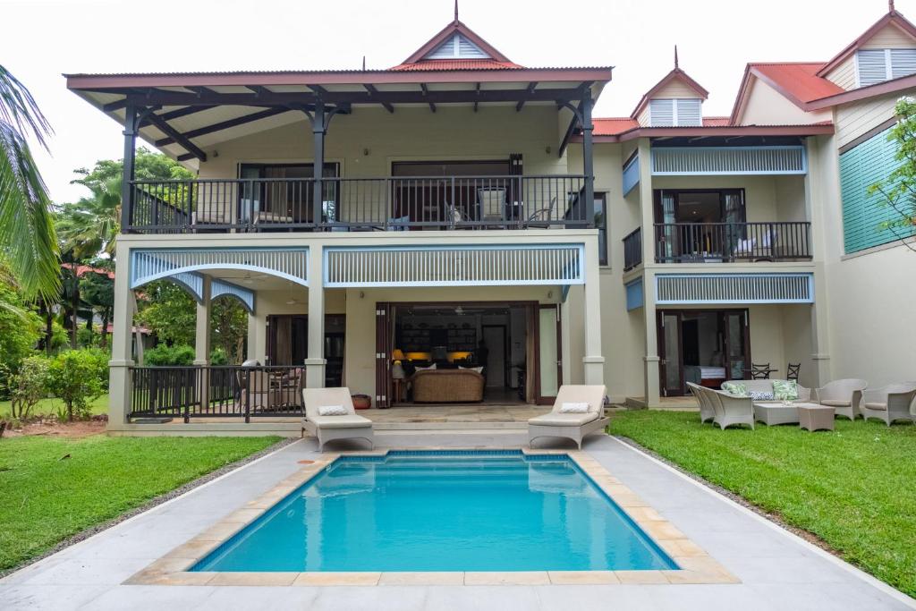a villa with a swimming pool in front of a house at Maison L'Amirale by Simply-Seychelles in Eden Island