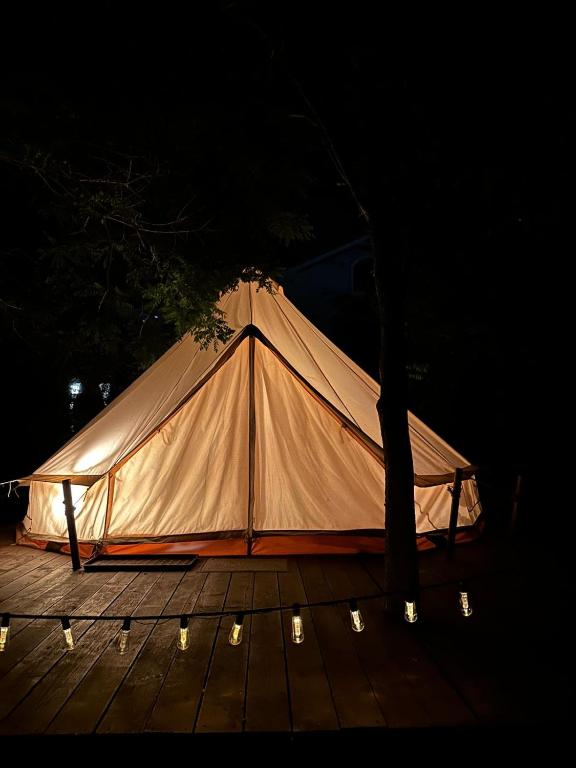 a white tent on a wooden deck at night at Glamping Cisnadioara in Cisnădioara