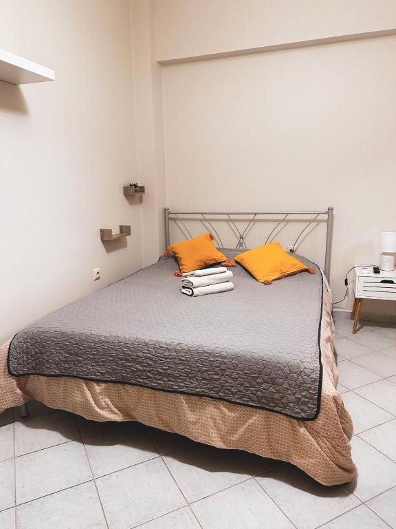 a bedroom with a bed with orange pillows on it at Efrosini downtown apartment in Chalkida