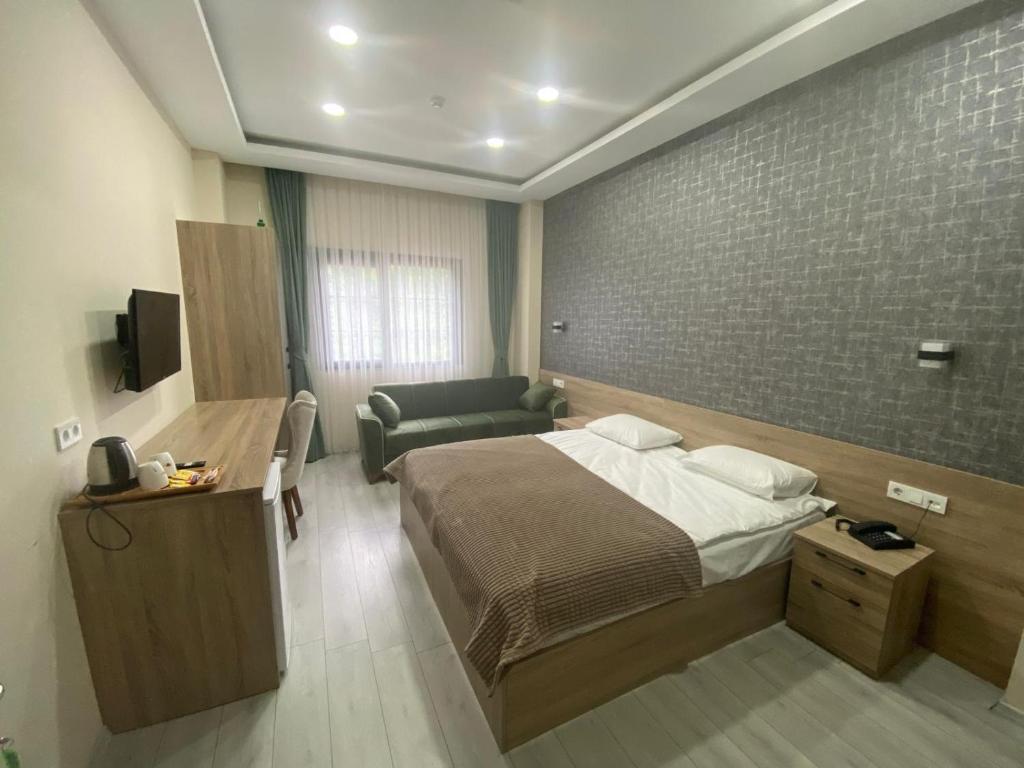 pokój hotelowy z łóżkiem i kanapą w obiekcie Lidzo Villa Butik Otel w mieście Trabzon