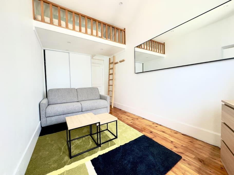 un salon avec un canapé et une table dans l'établissement Appartement Mezzanine Cosy 4P Champs elysées, à Paris