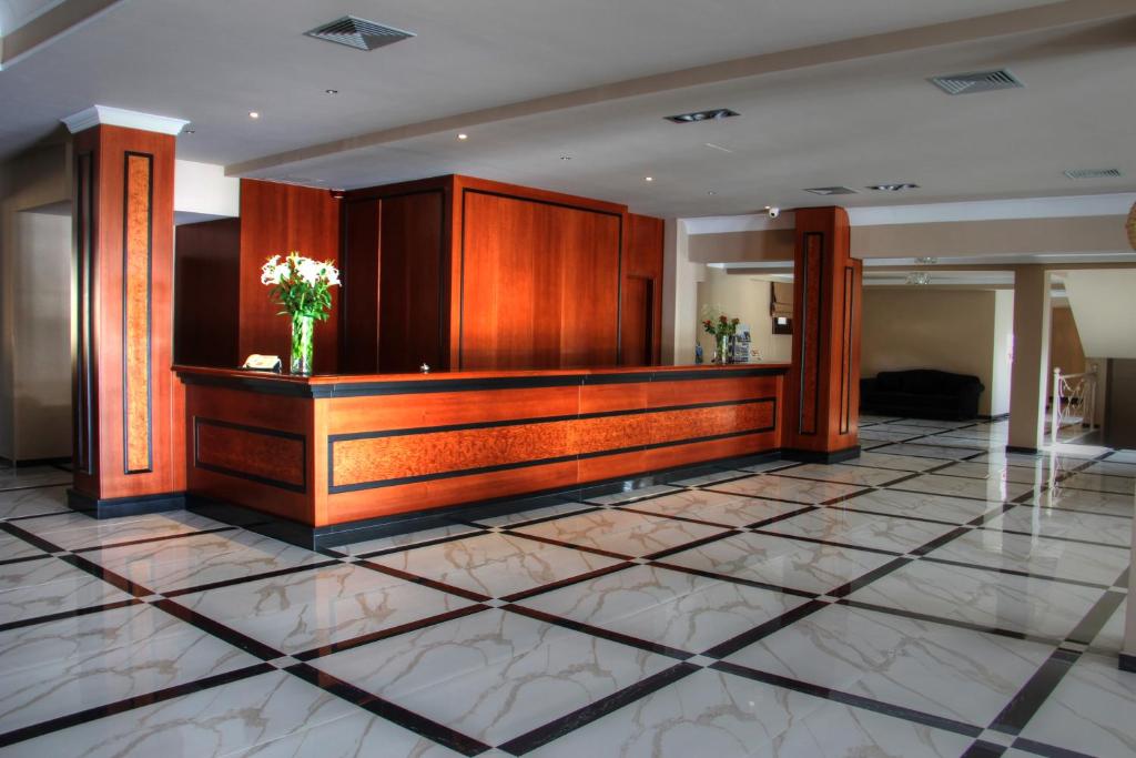 a lobby with a podium with a vase of flowers at Grand Meteora Hotel in Kalabaka