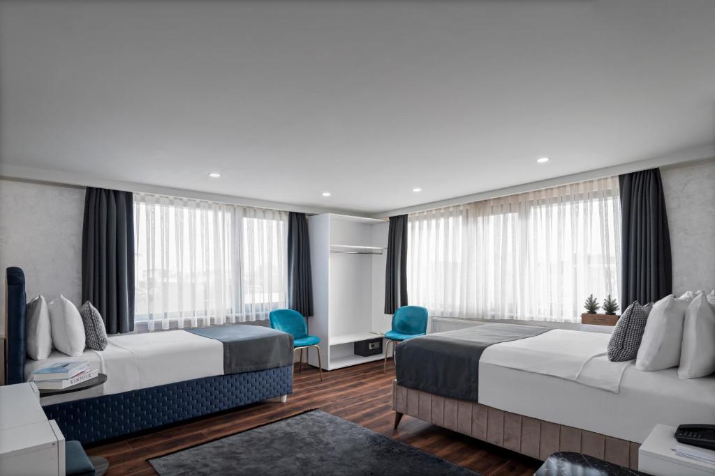 a hotel room with two beds and blue chairs at İstanbul Efes Hotel in Istanbul