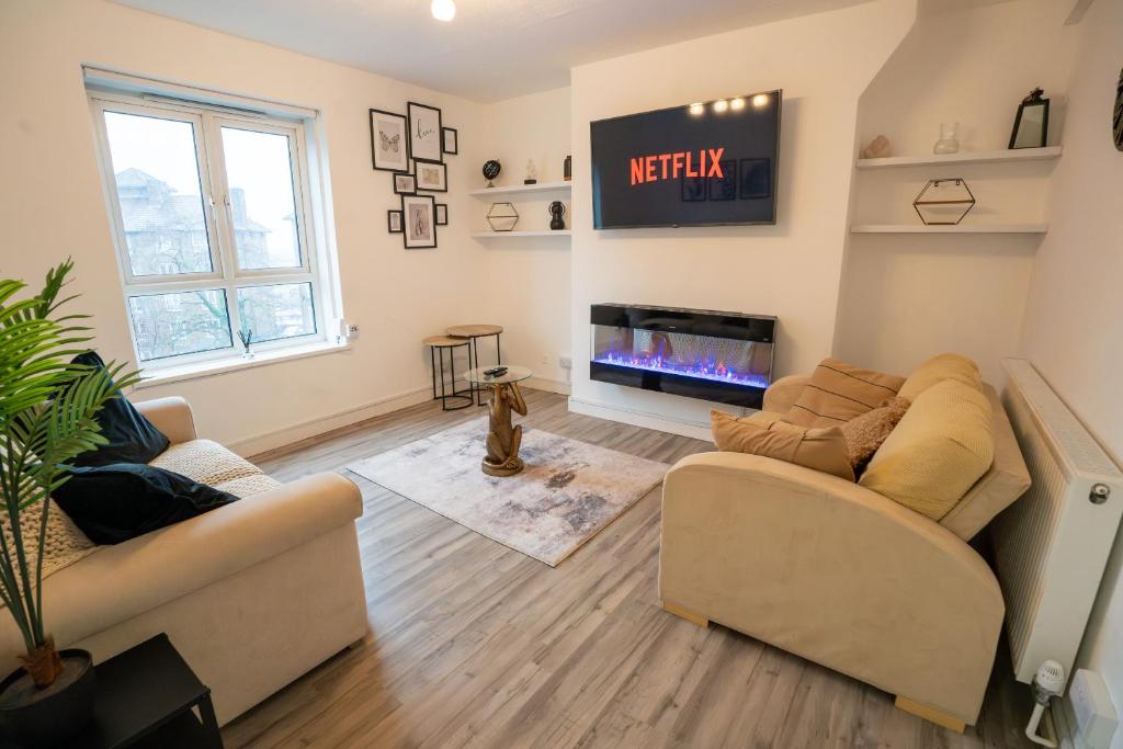 - un salon avec deux canapés et une télévision dans l'établissement Hackney Haven!, à Londres