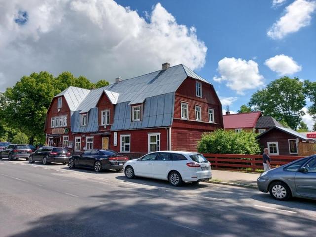 a large red house with cars parked in front of it at Janune Kägu in Koeru
