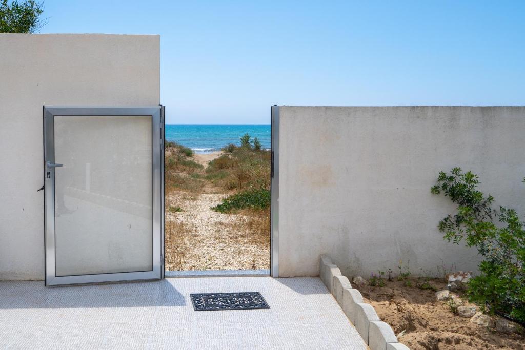 eine Tür, die zu einem Strand mit dem Meer führt in der Unterkunft Villa Rosa con accesso sul mare in Pachino