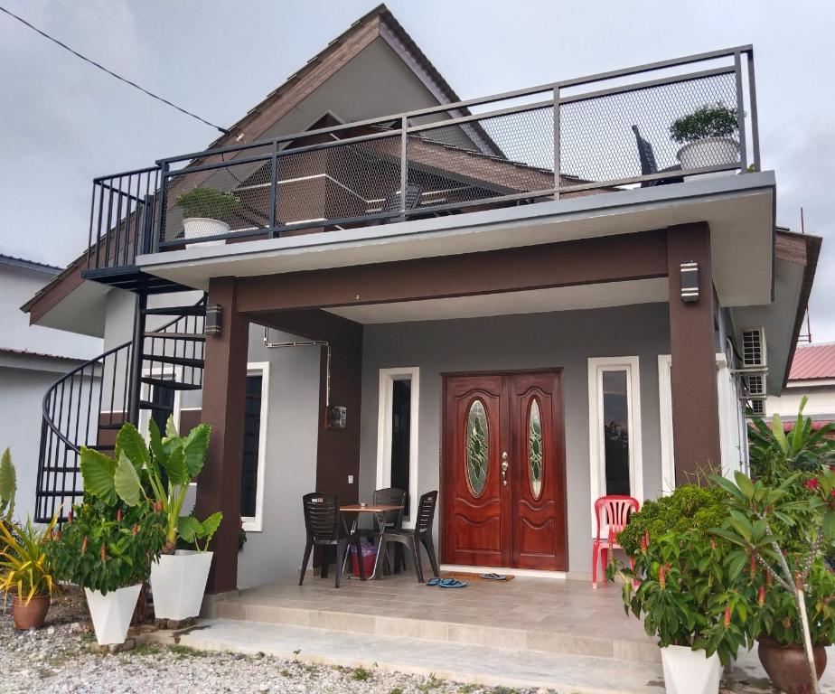 a house with a balcony and a wooden door at Villa Adeeva Homestay Langkawi in Pantai Cenang