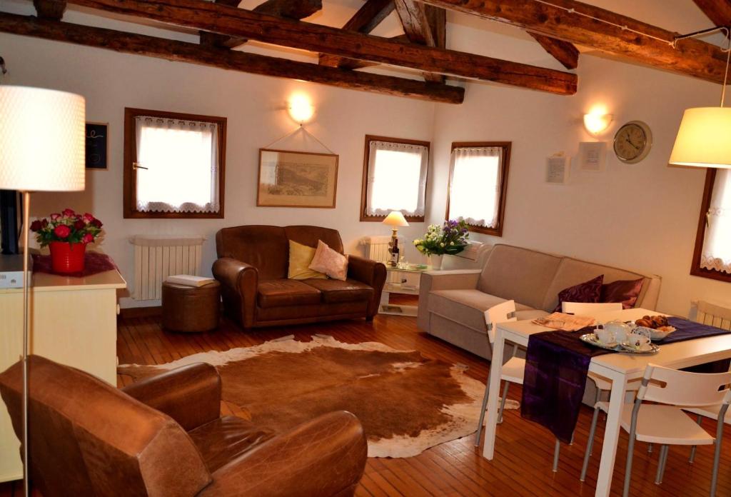 ein Wohnzimmer mit einem Sofa und einem Tisch in der Unterkunft Attico San Marco in Venedig