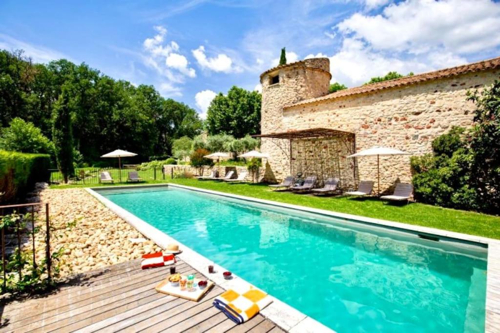 une piscine devant un bâtiment en pierre dans l'établissement La Grande Verrière - MH, à Goult