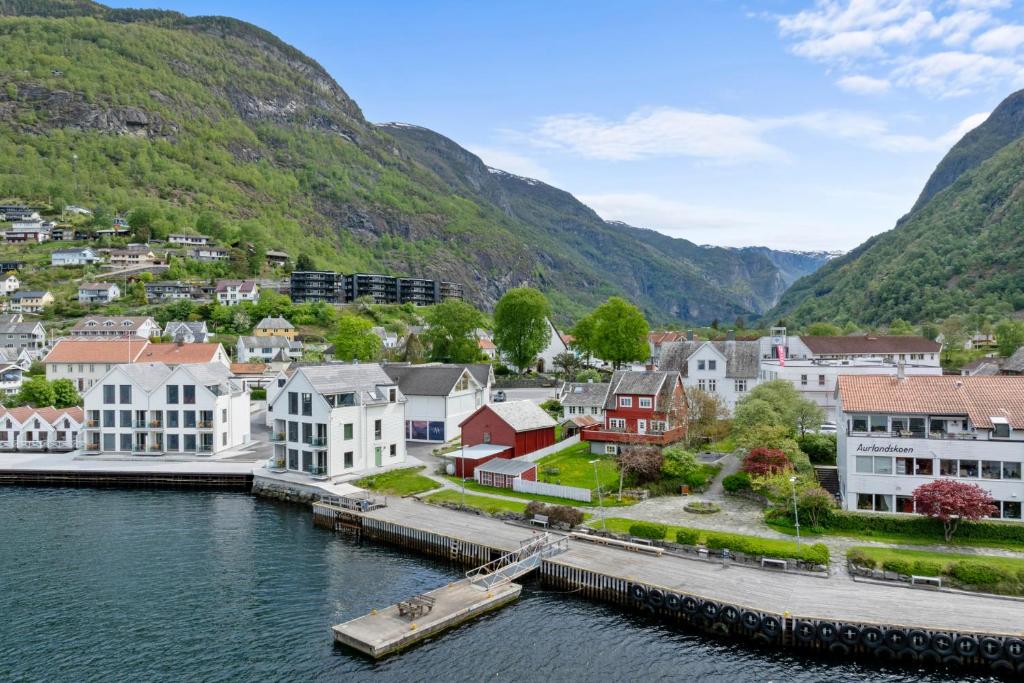 a small town next to a river with mountains at Aurland Guesthouse in Aurland
