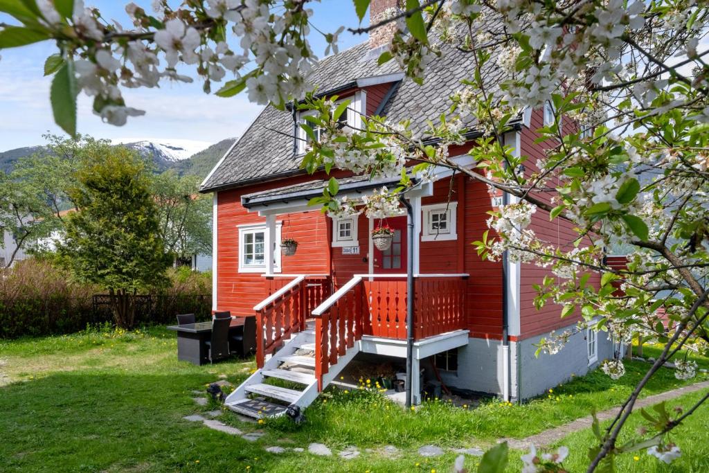 a red house with white windows and a porch at Aurland Guesthouse in Aurland
