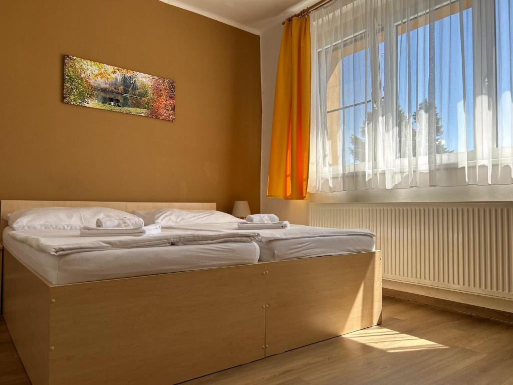 Cama en habitación con ventana grande en Pension Fontana, en Poděbrady