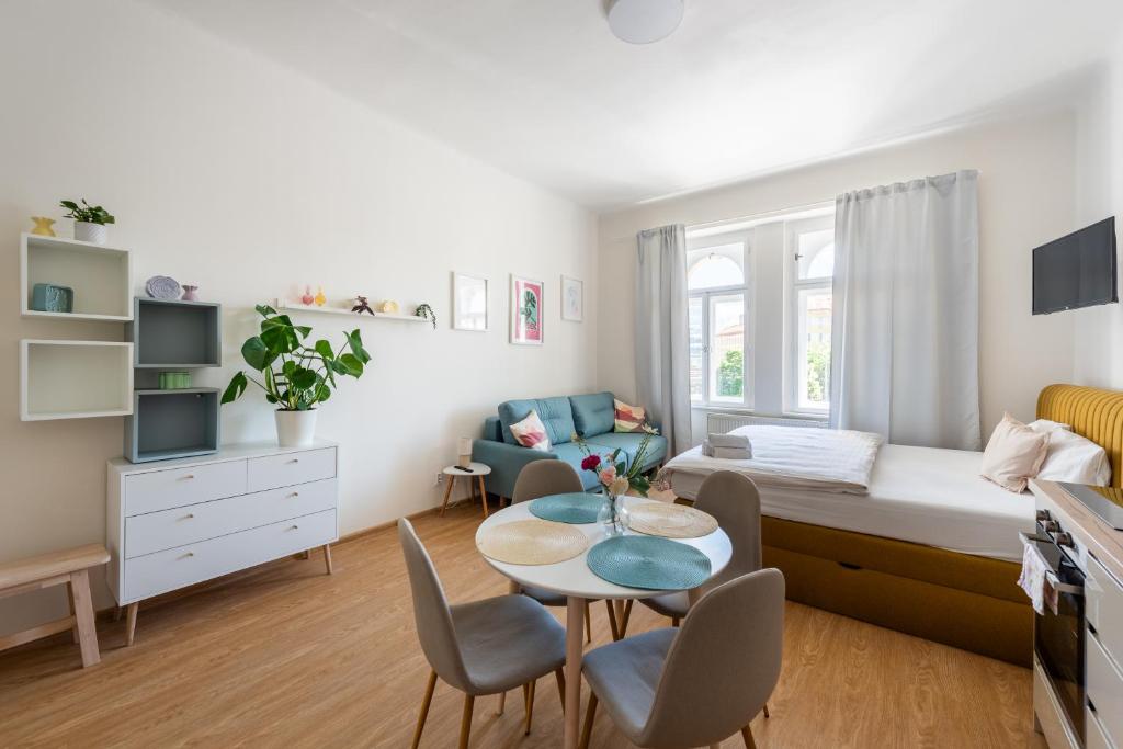 een kleine kamer met een bed en een tafel en stoelen bij Tesnov Residence Apartments in Praag