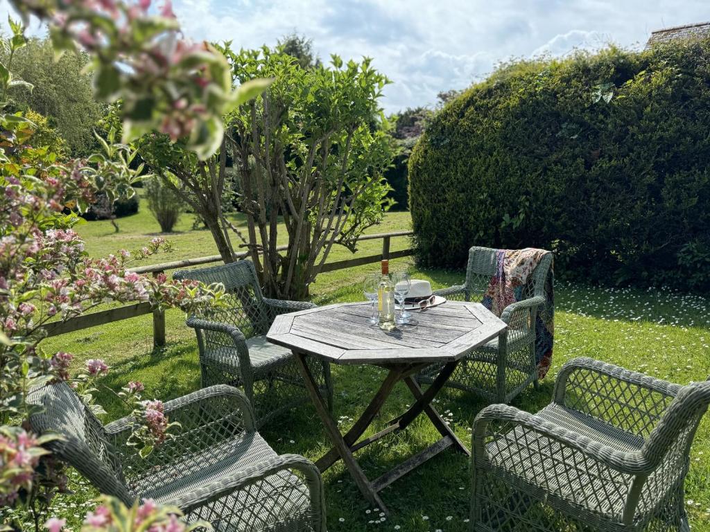 una mesa y sillas en un jardín con mesa y sillas en Primrose Cottage - South facing cottage in the heart of Dittisham, en Dittisham