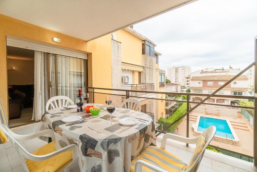 Un comedor con mesa y sillas en un balcón. en Apartamento completo con piscina y amplio balcón, en Cunit