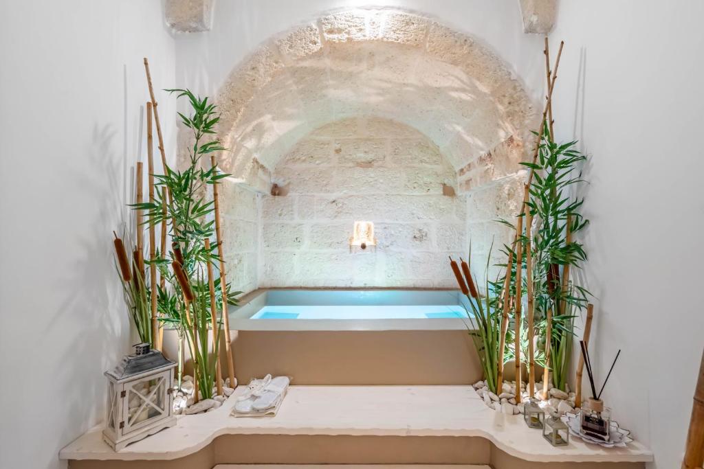 bañera en una habitación blanca con plantas en MeoLuxury Suite&Deluxe by Rentbeat, en Fasano