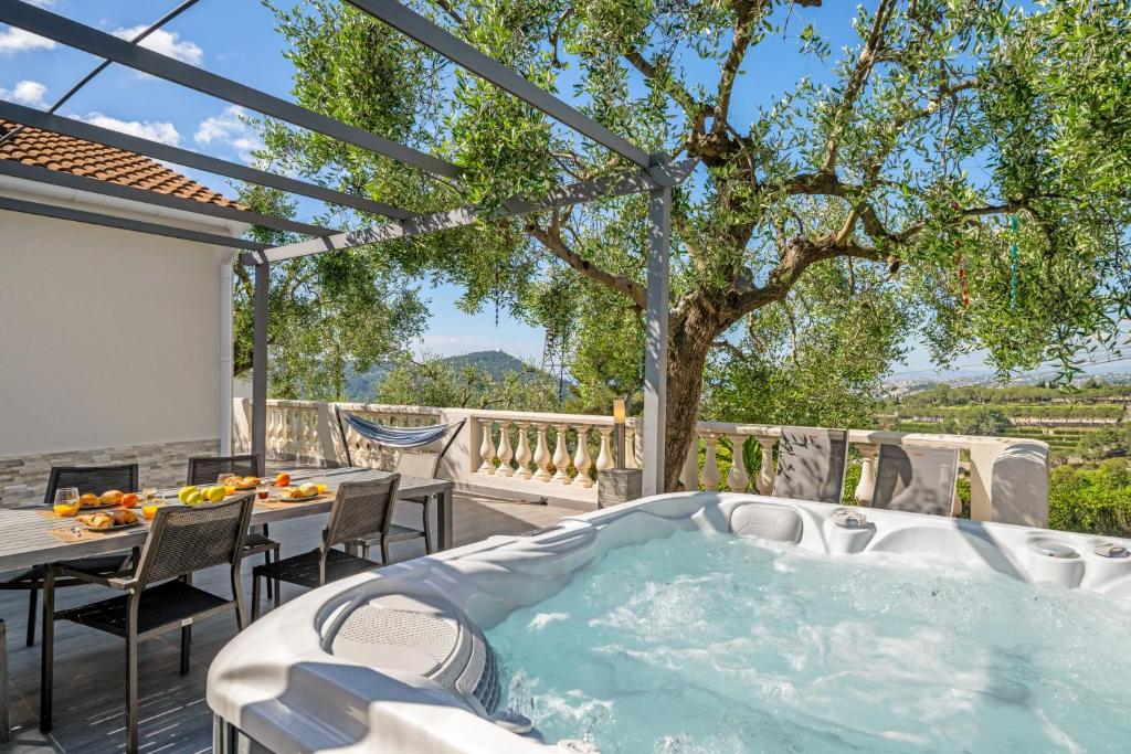 a hot tub on a patio with a tree at Villa vue mer, terrasse et spa in Nice