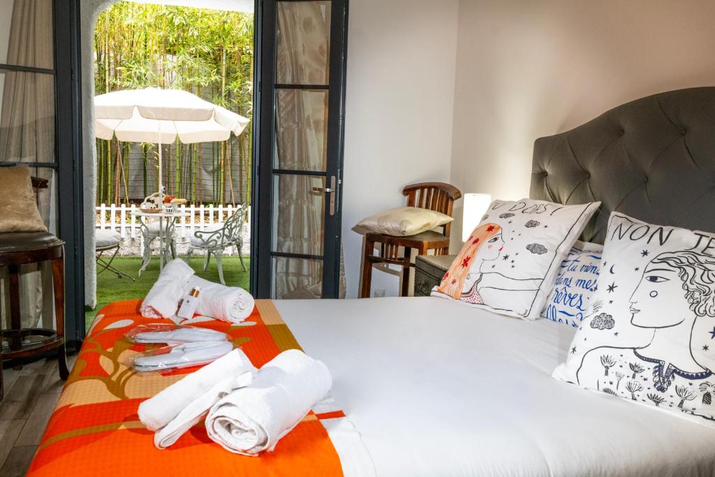 una camera da letto con un letto e asciugamani di Les Canoubiers Luxe et sérénité au cœur de Saint-Tropez Suites spacieuses avec jardin enchanteur a Saint-Tropez