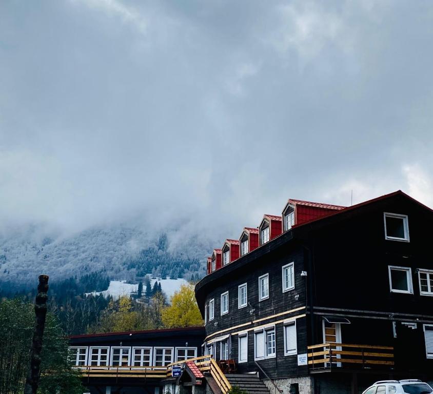 a large building with a mountain in the background at Hotel Pod Sokolím in Terchová