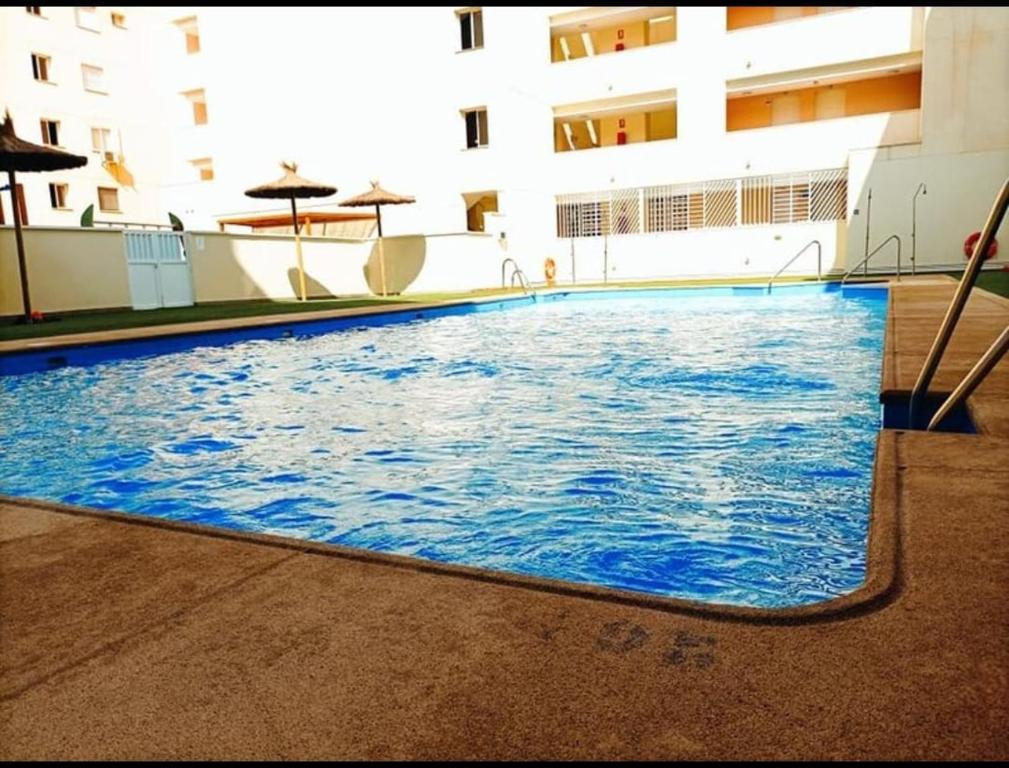 una gran piscina azul en un edificio en LyriosHomes Beach Roquetas de Mar, en Roquetas de Mar