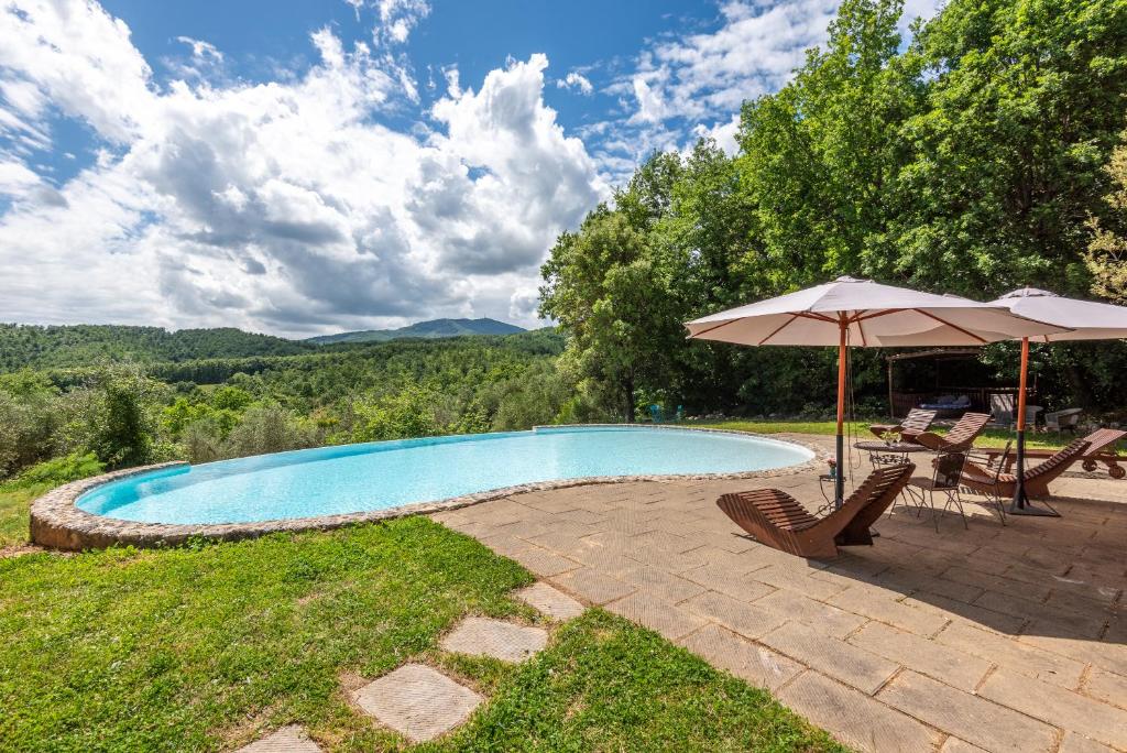 una piscina con sombrilla y 2 sillas en Paradis Oasis Santa Maria en Chiusdino