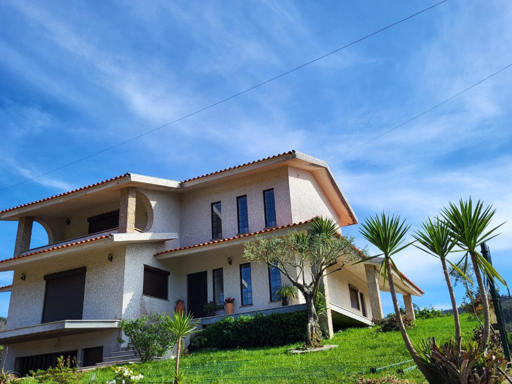 une grande maison avec des palmiers en face de celle-ci dans l'établissement Casa de Santo Amaro, à Aveiro
