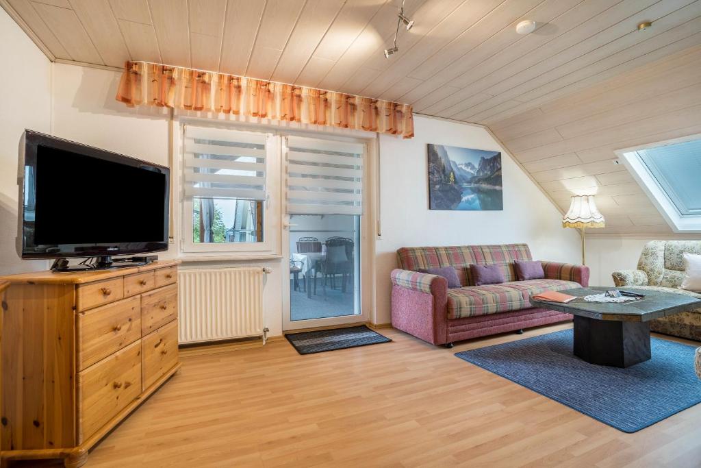 uma sala de estar com uma televisão de ecrã plano e um sofá em Ferienwohnung Viola in Schwanau em Schwanau
