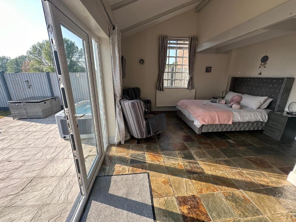 a bedroom with a bed and a sliding glass door at Dwylig Isa Holiday Cottages in Rhuddlan