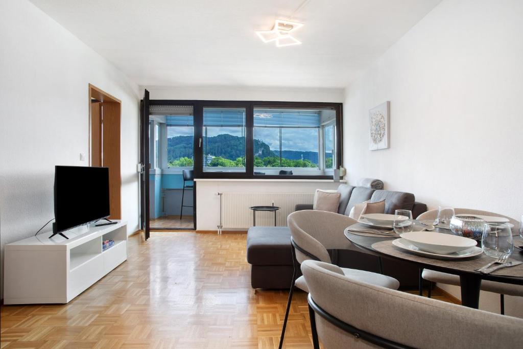 een woonkamer met een bank en een tafel met een televisie bij Ferienwohnung am Bodensee in Bregenz