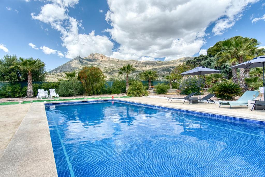 una piscina con una montaña en el fondo en Finca Rustica, en Jijona