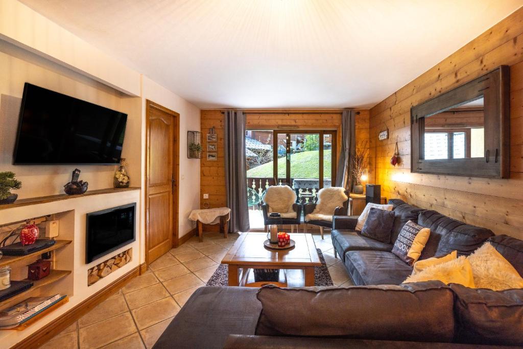 sala de estar con sofá y TV en Refuge de l' Alpage en Morillon
