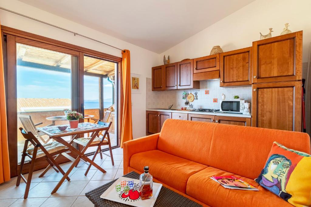 sala de estar con sofá naranja y mesa en Bella Vista Castelsardo, en Castelsardo