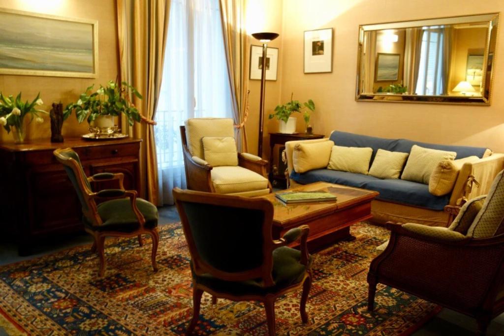 un salon avec un canapé bleu et des chaises dans l'établissement 55 m2 apartment very quiet close to the Eiffel Tower, à Paris