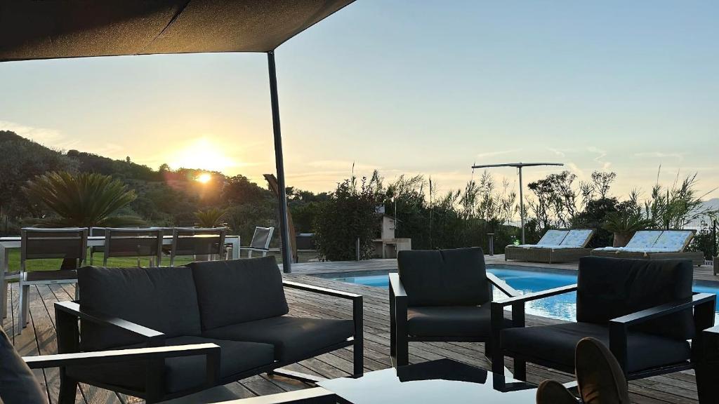 a patio with two chairs and a swimming pool at Résidence Aigue Marine in Coti-Chiavari