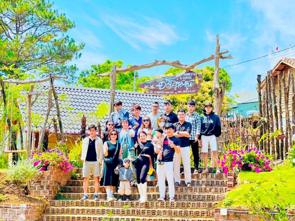 a group of people posing for a picture on some stairs at Đồi Gió Hú Homestay & Coffee - Măng Đen in Kon Tum