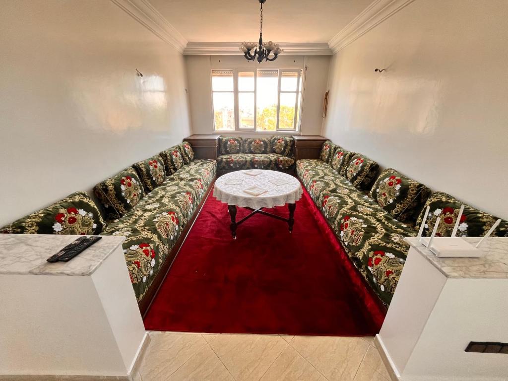un soggiorno con divano e tappeto rosso di Casablanca Beautiful and Tranquil Family Apartment a Casablanca
