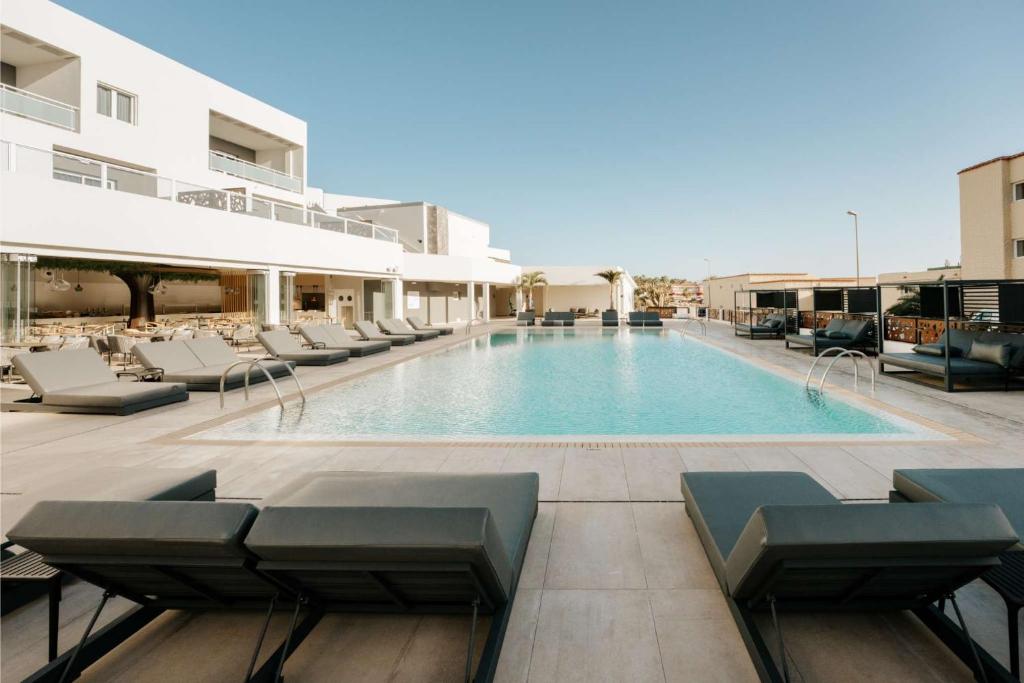 uma piscina com espreguiçadeiras e um hotel em R2 HIGOS BEACH em Costa Calma