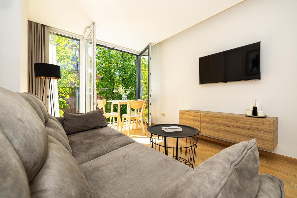 a living room with a couch and a tv at Central Square Apartments in Palanga