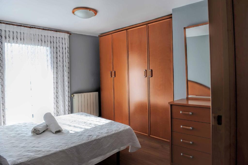 a bedroom with a bed and a dresser and a mirror at Casa Sabelín in Suesa