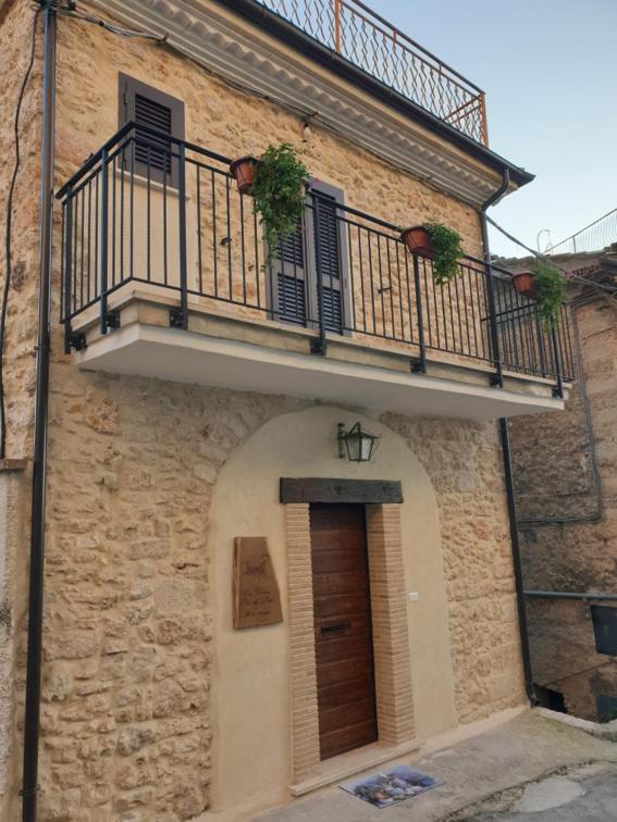kamienny budynek z balkonem i drzwiami w obiekcie Casa Vacanza Orto dei Preti w mieście Collepardo