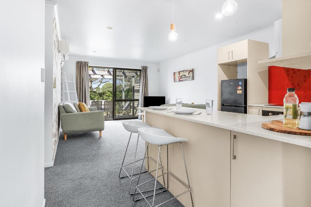 a kitchen with white cabinets and bar stools at Park view, Proximity, Value in Hamilton