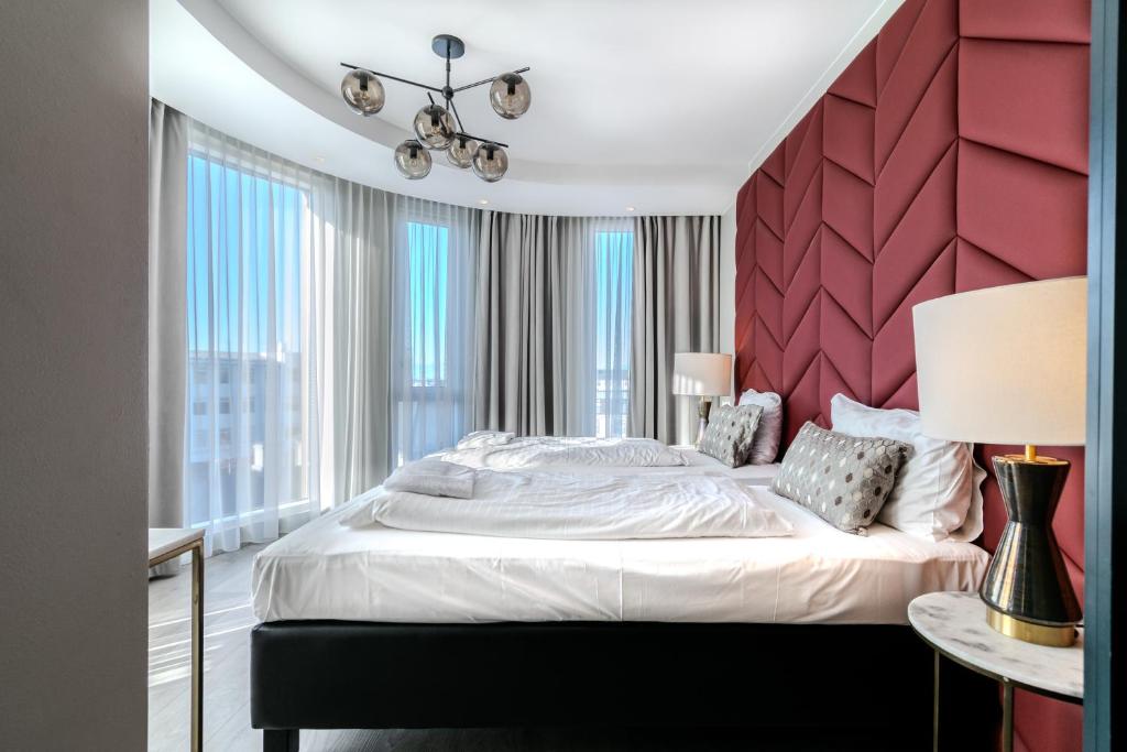 a bedroom with a large bed with a red headboard at Midtown Hotel in Reykjavík